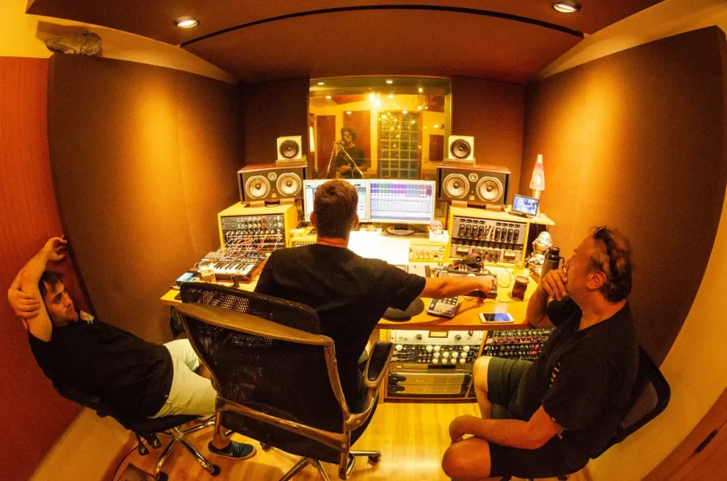 Producers and engineer reviewing a drum recording session in the control room